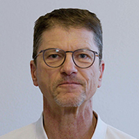 Ein Mann mittleren Alters mit kurzen Haaren und Brille